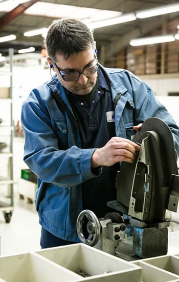 un employé defontaine en veste bleue utilise une machine de production